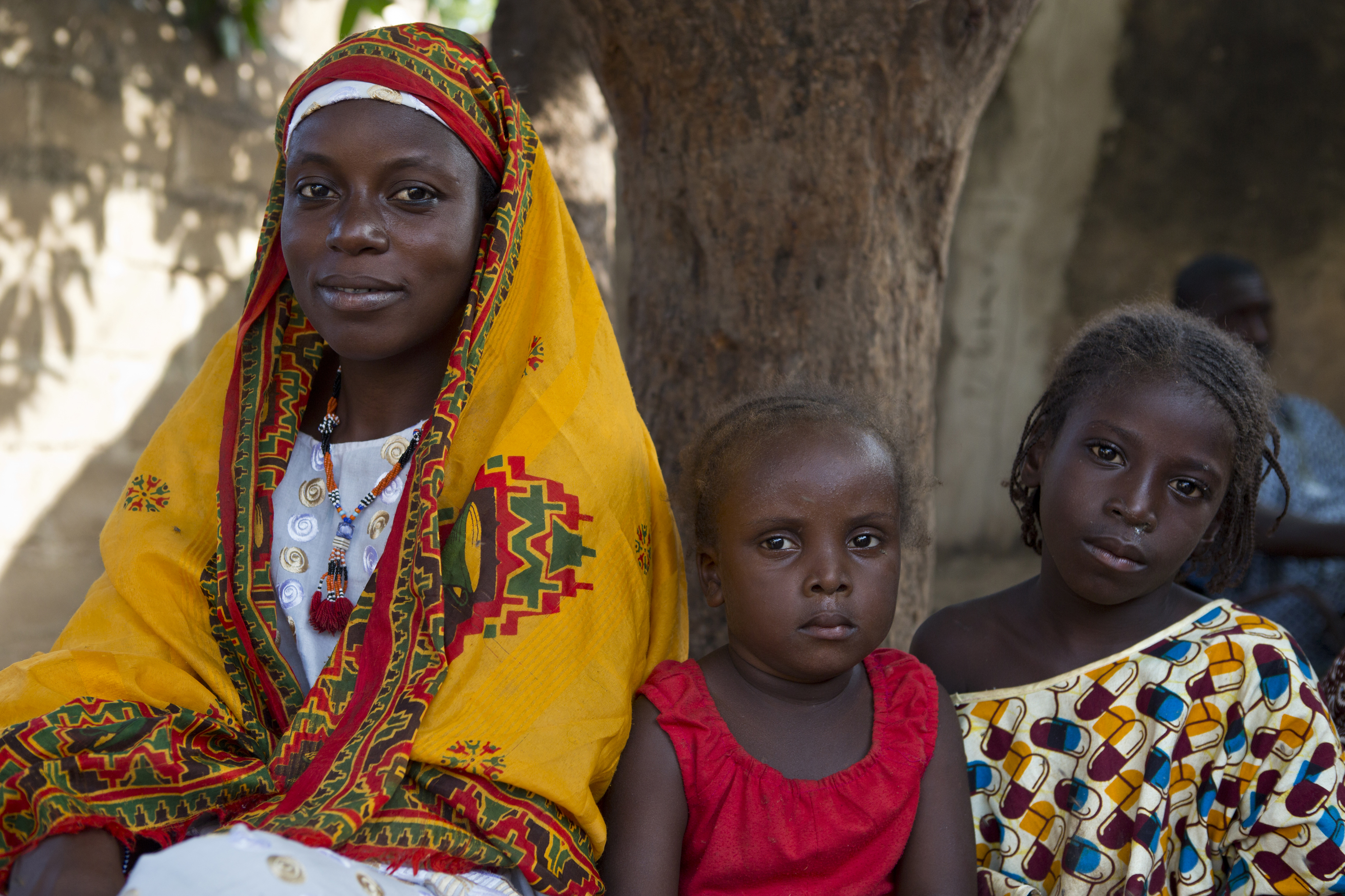 A colorful family portrait of three of the almost 200,000 internally displaced people in Mali.