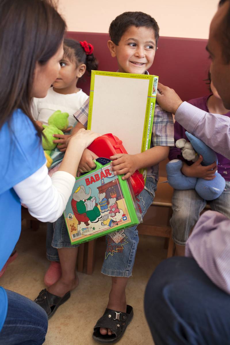 This four-year-old boy struggles to hold onto his toys.