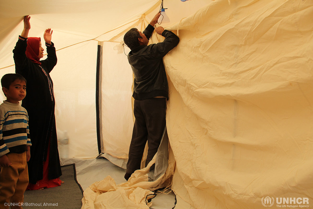 An Iraqi family displaced by the fighting in Mosul put up their tent at Hasansham camp, as UNHCR delivers cold weather supplies, including warm blankets and stoves.