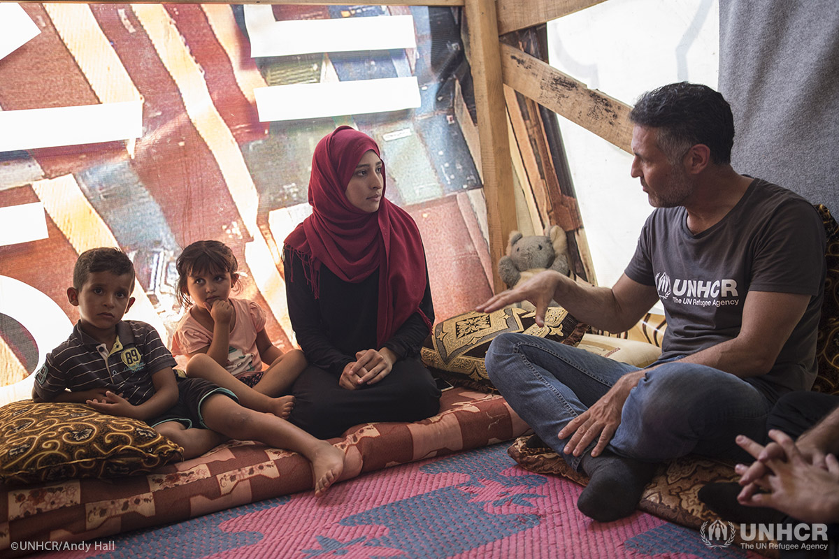 Noura speaks with Khaled as Ziad and Rawa'a look on.