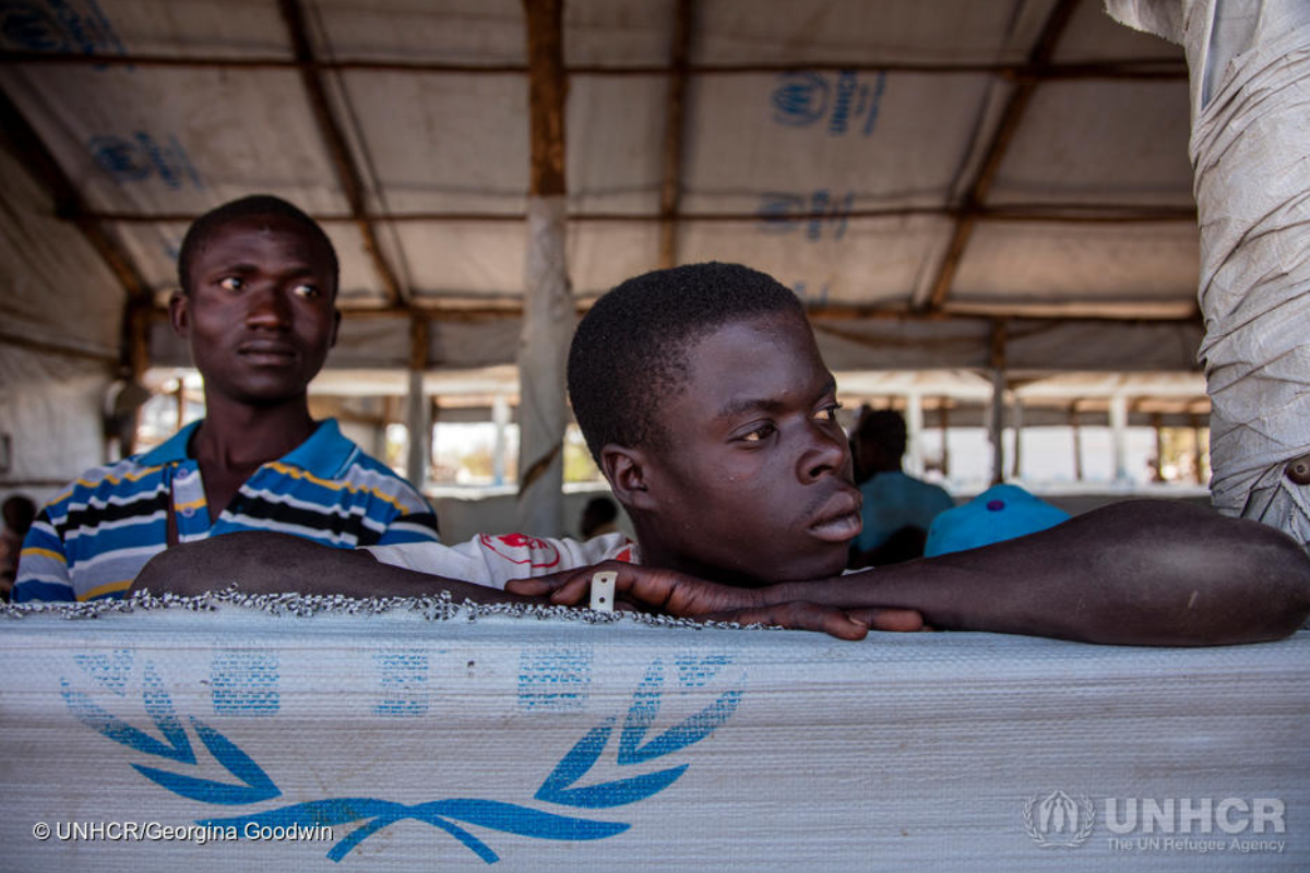 Young ment from South Sudan look out a window