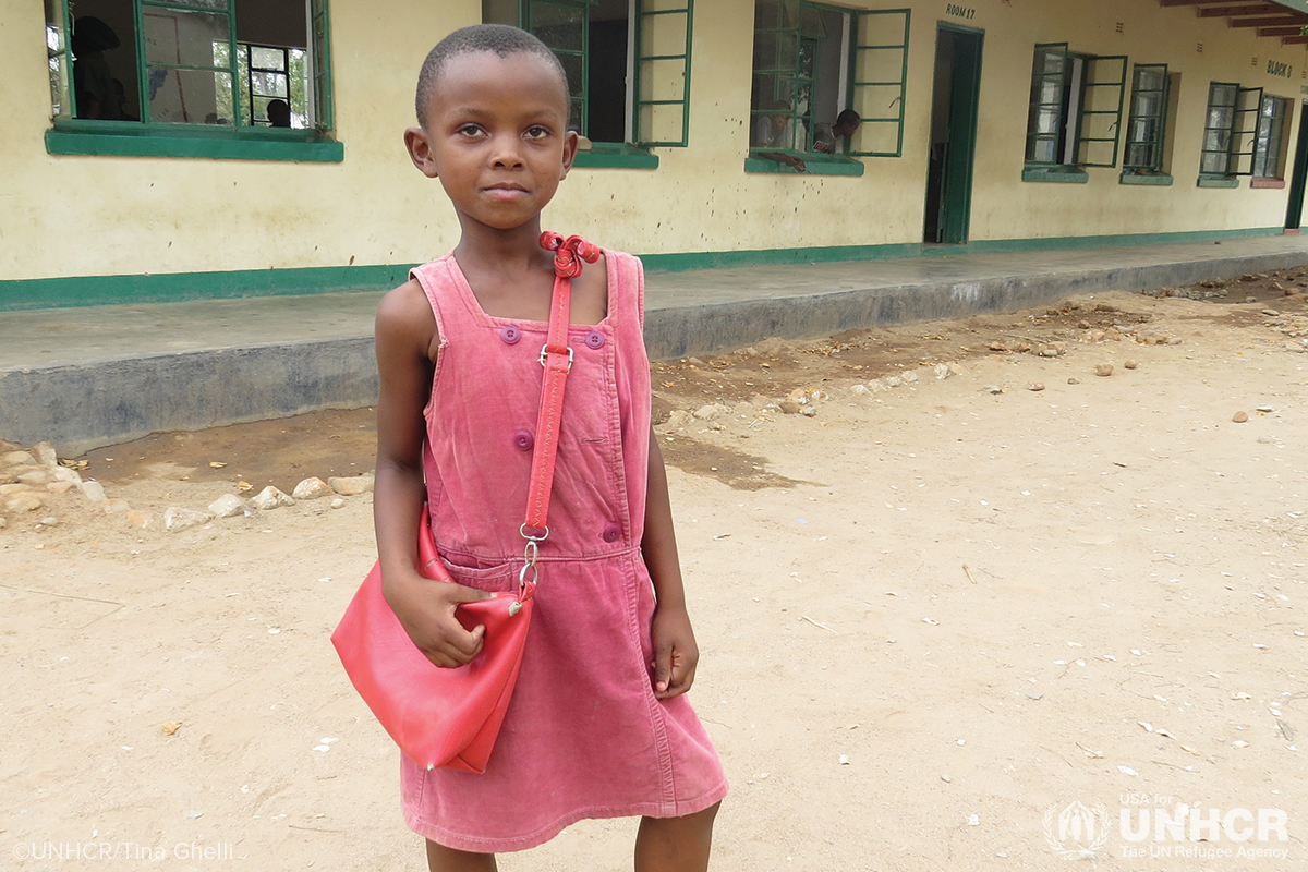 erika wearing a pink dress standing outside her school