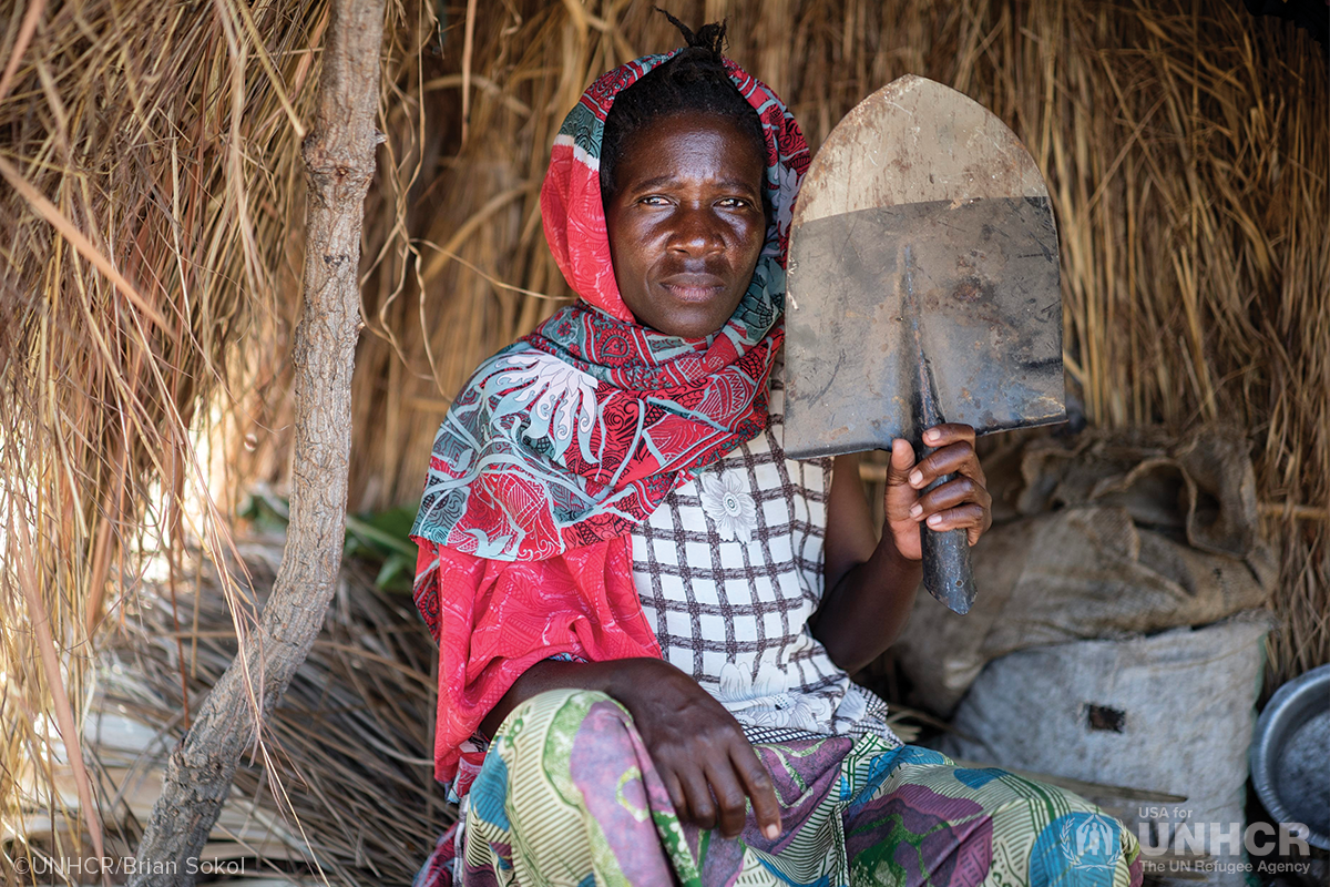 generose sits in her home holding the head of a shovel