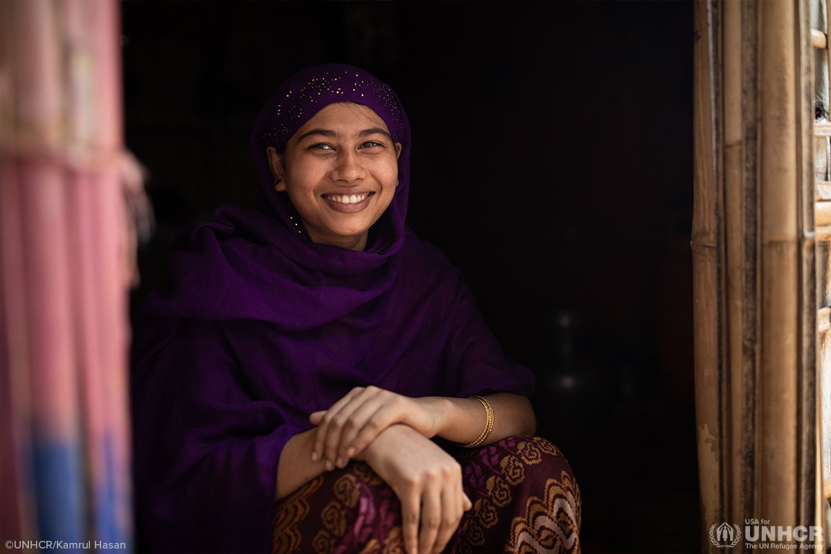 ayesha sitting in a doorway smiling at the camera