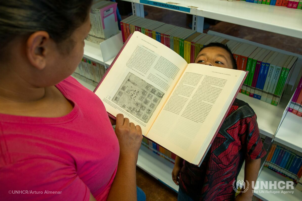 Samuel, boy from El Salvador looks over book