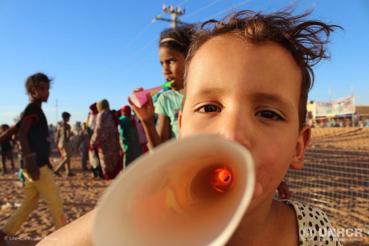 child speaking through paper megaphone