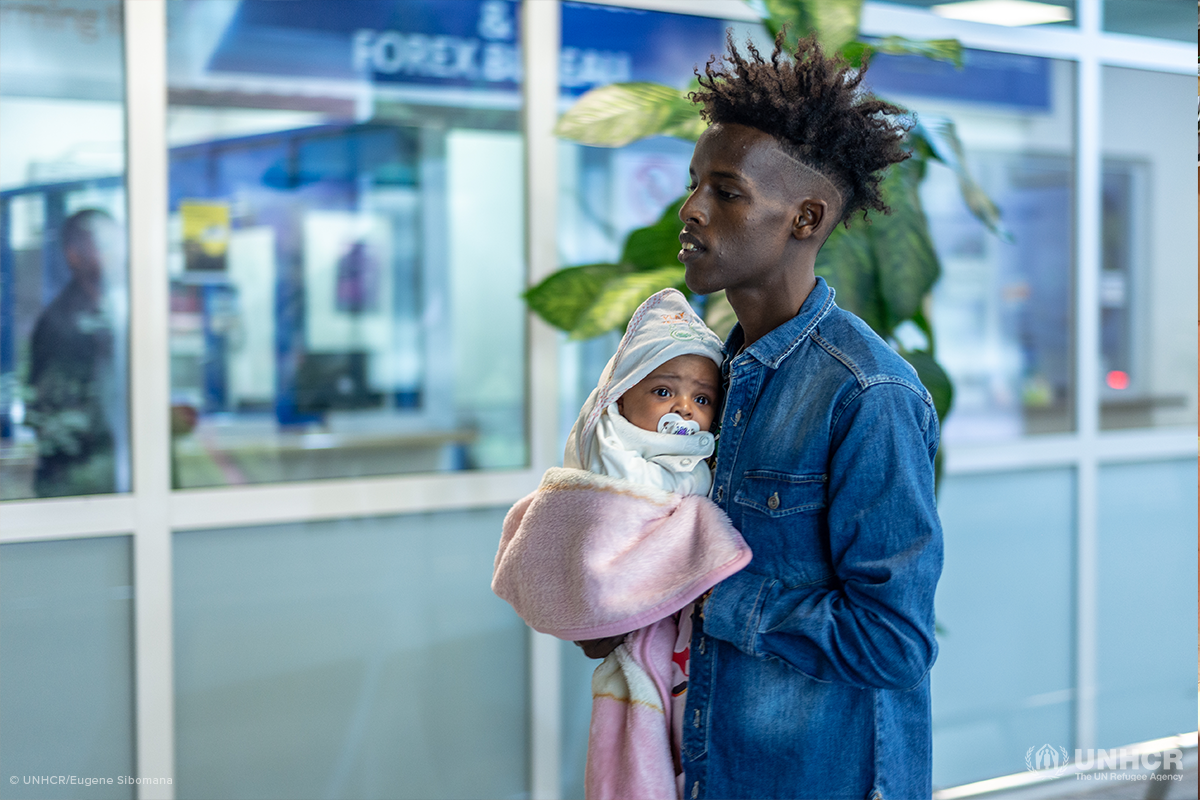 somali refugee father holding his infant daughter