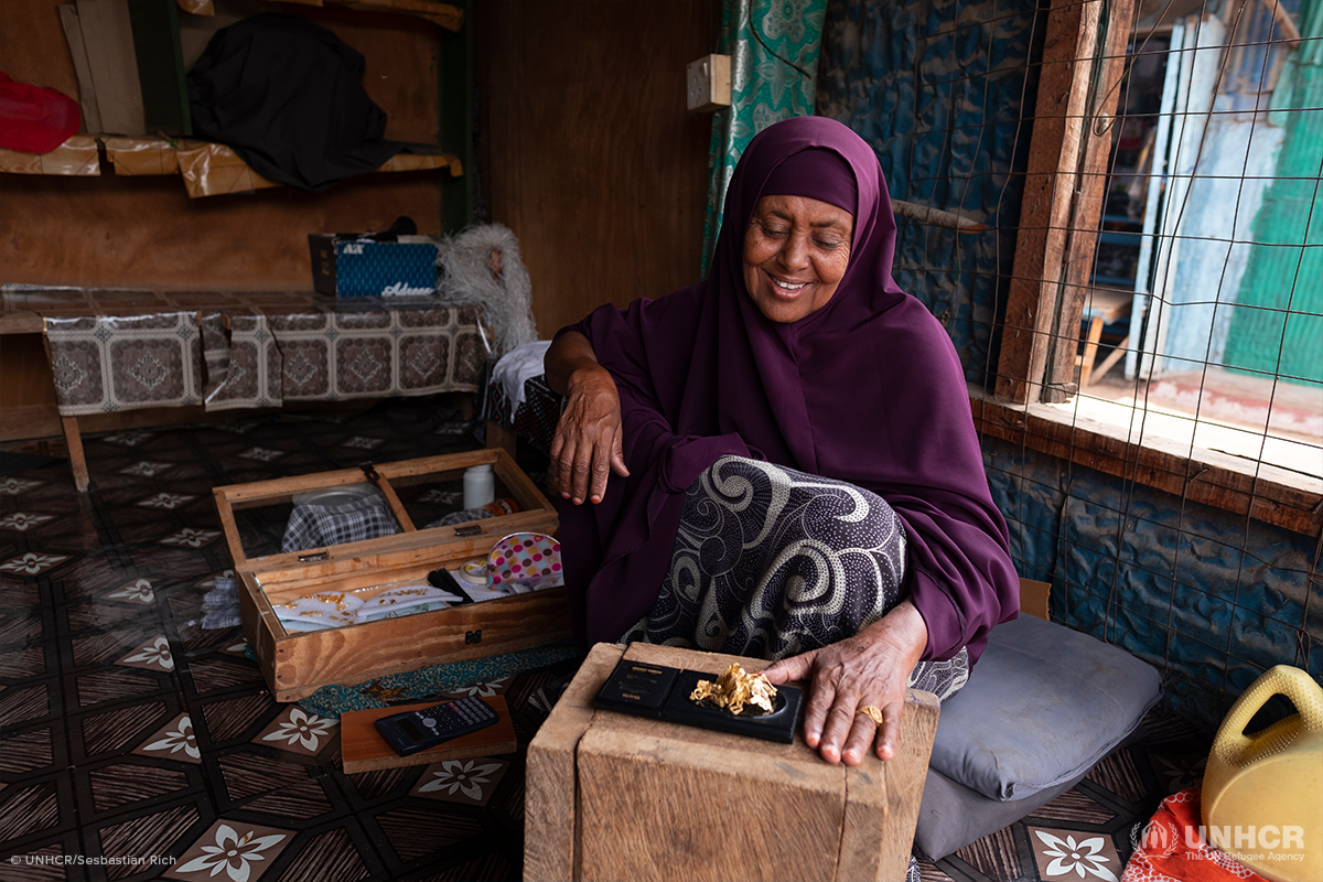 somali refugee woman weighing jewelry in her shop