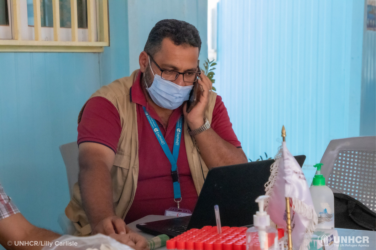 ibrahim talking on the phone and working at his laptop