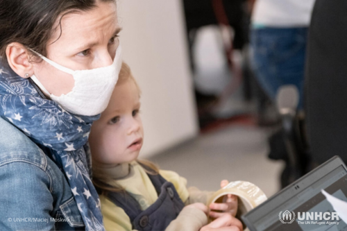 Rozalia provides her details to a staff member at UNHCR’s cash enrollment center in Warsaw.