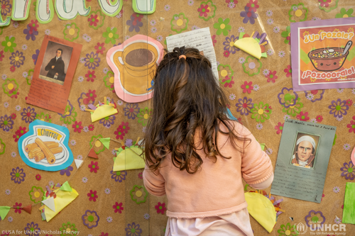 Child looking at wall with her back to the camera.