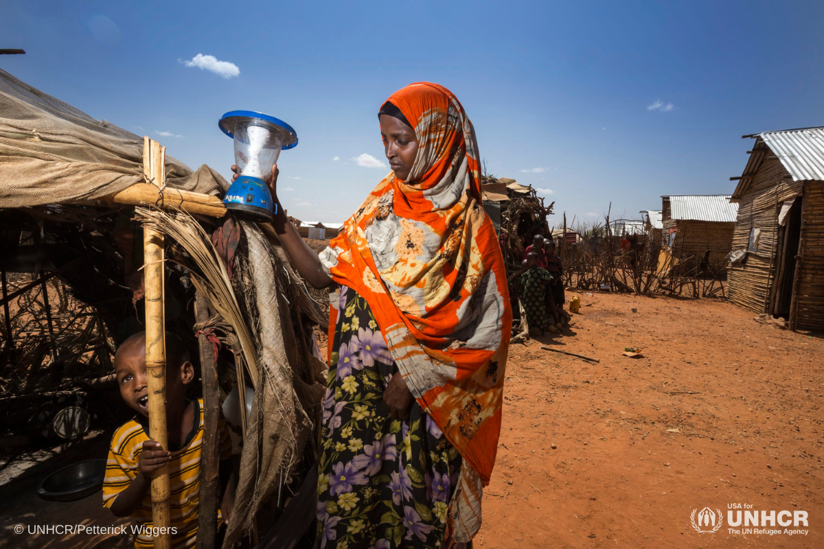 A Somali refugee in Kobe Refugee Camp, Ethiopia travels via cart past a solar powered street light.