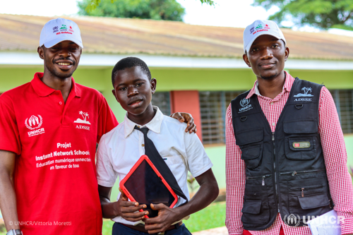 Jospin holds a red tablet, standing between two INS coaches.