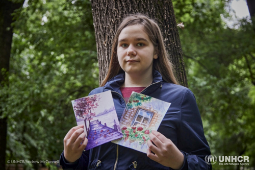 Kate, a 17-year-old Ukrainian refugee from Kyiv, with some of her sketches in a park in Bucharest, Romania.