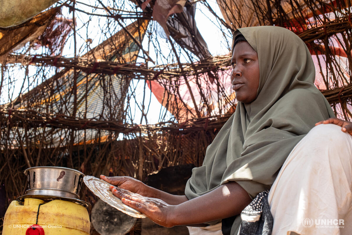 Hajira a Somali refugee cleans dishes in her shelter