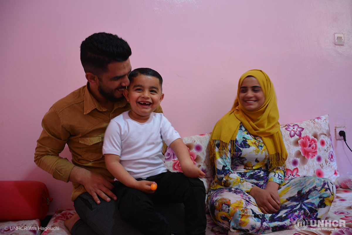 Nidal laughs with his son and wife