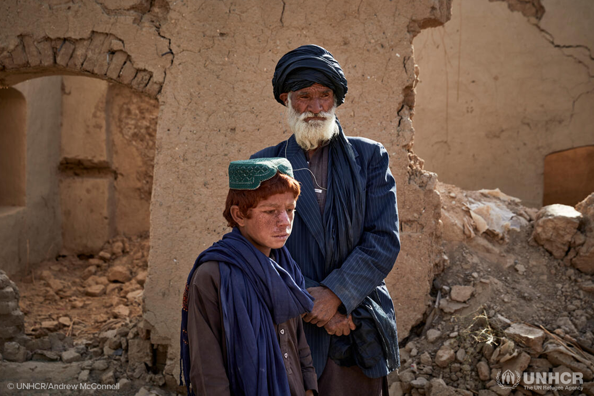 Sayed Mohammad and his son stand in their damaged home in Marja