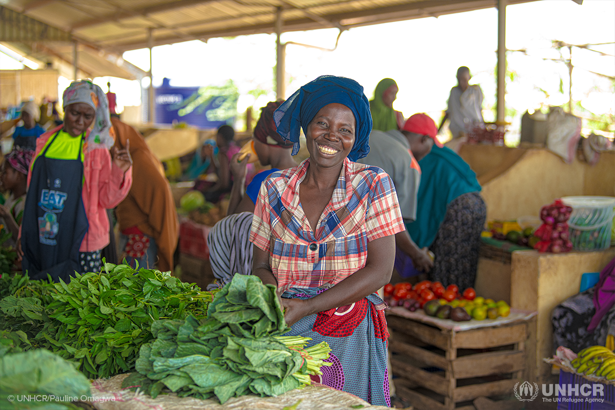 Serafina smiling in front of her vegetable stand