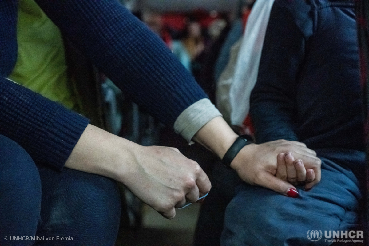 Displaced people from Ukraine hold hands