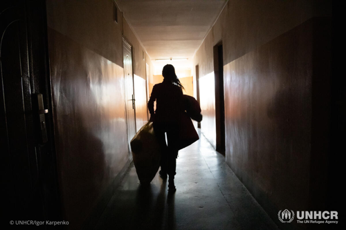 Oleksandra, who fled her home in the eastern part of Ukraine, takes blankets and warm clothes back to her family’s room at a dormitory in the west of the country.