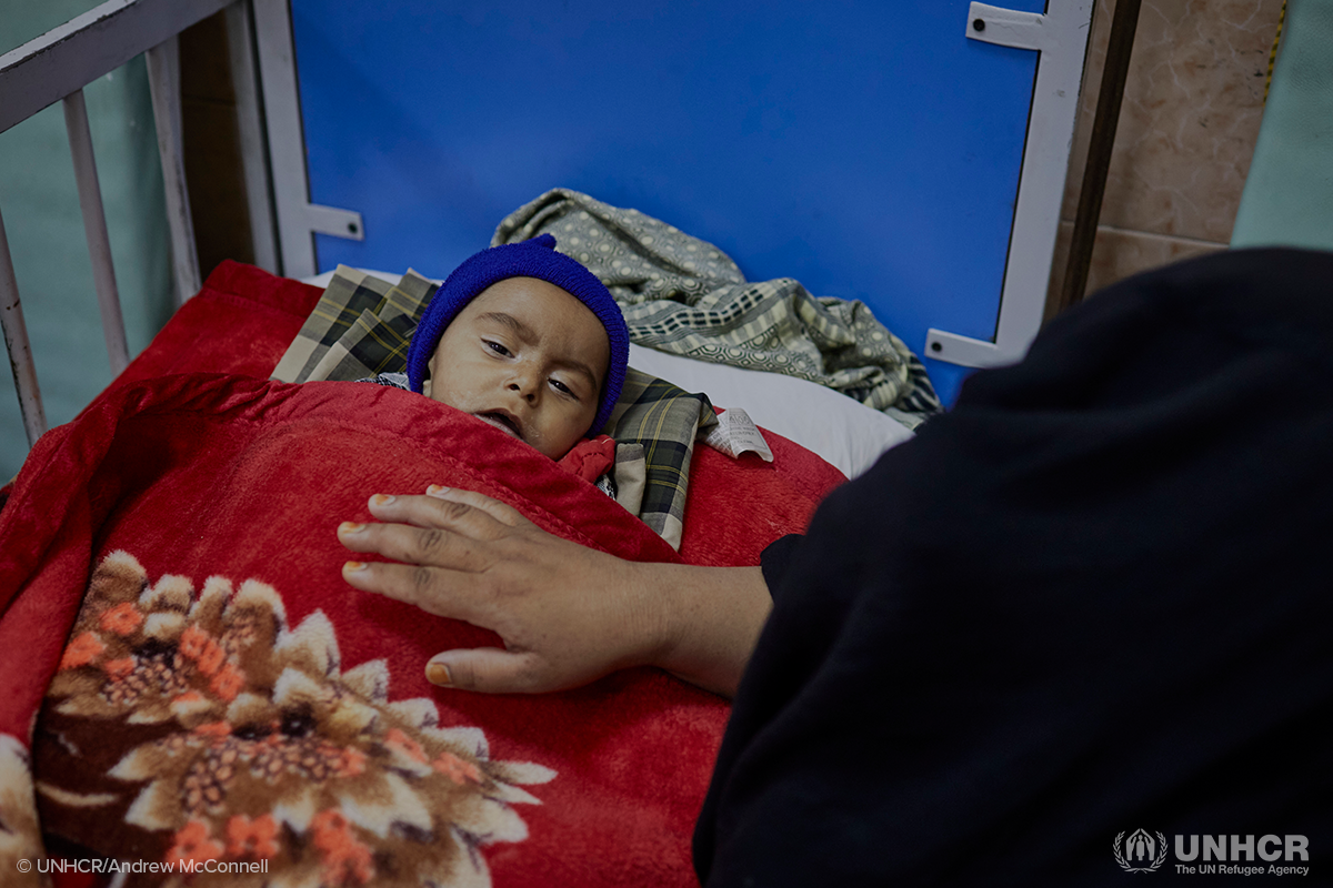 Displaced Afghan child being comforted by his mother