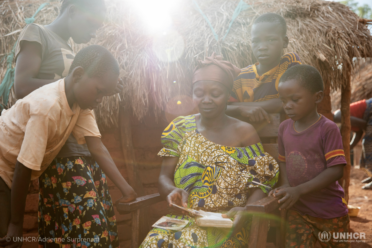 Woman sitting with family outside shelter