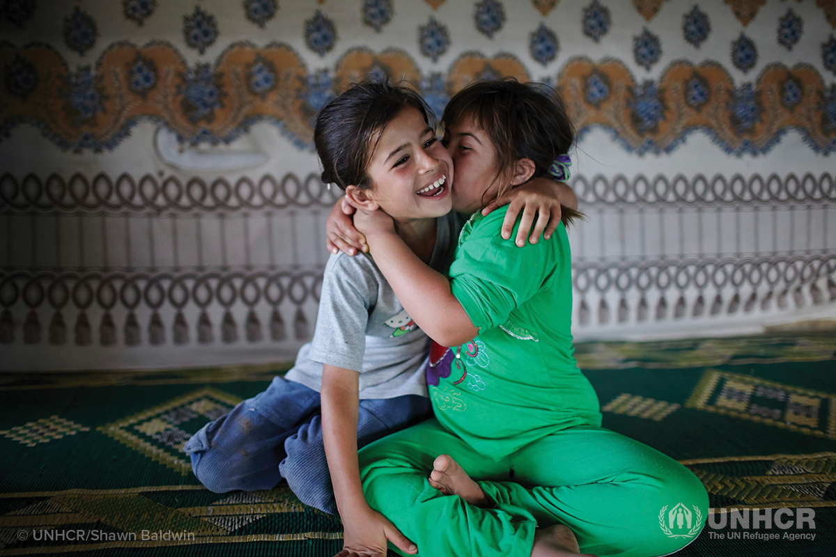 syrian sisters in a refugee camp hold each other