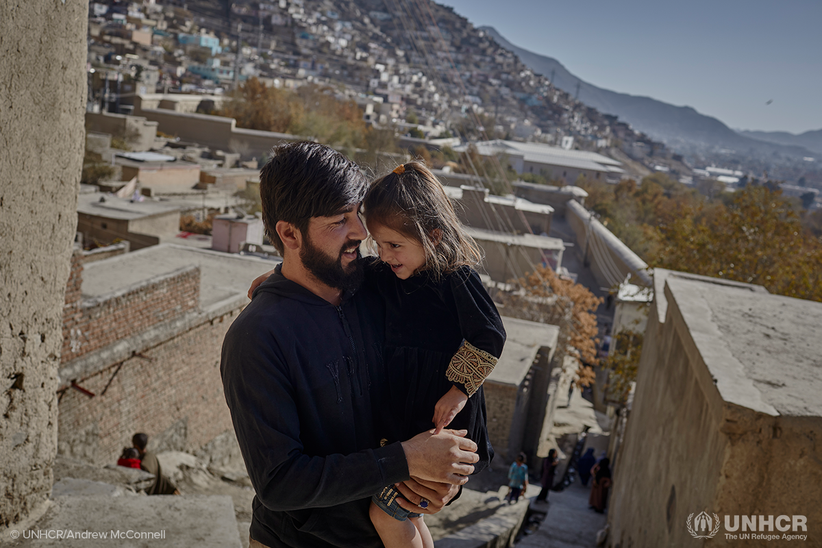 abdul and his daughter stand outside their shelter