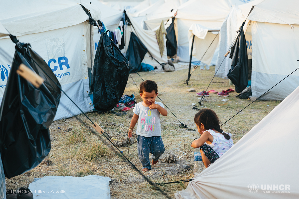 Two young asylum seekers from Afghanistan play in a clearing between tents, inside the Mavrovouni emergency site on the Greek island of Lesbos